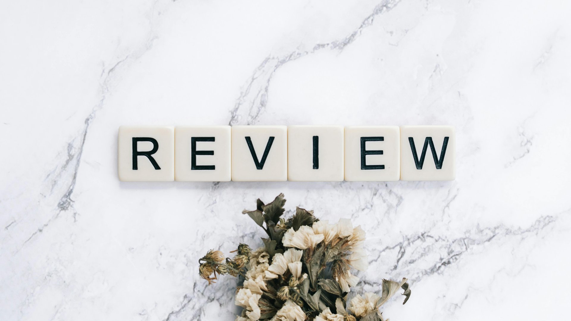 Lettres formant le mot review sur un fond de marbre